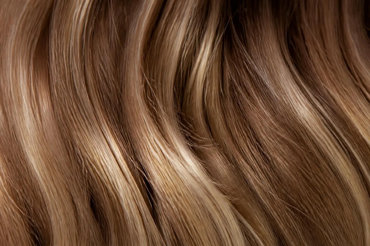 Primo piano di capelli con babylights color miele su base castano chiaro