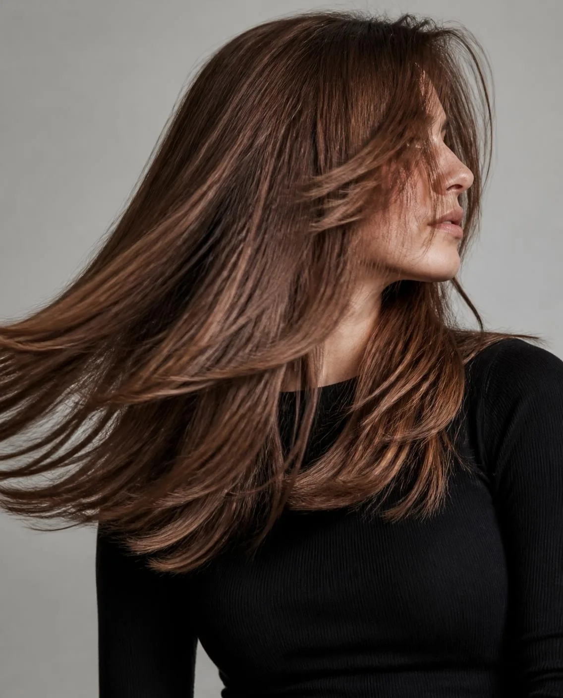 Donna con lunghi capelli scalati castani in movimento